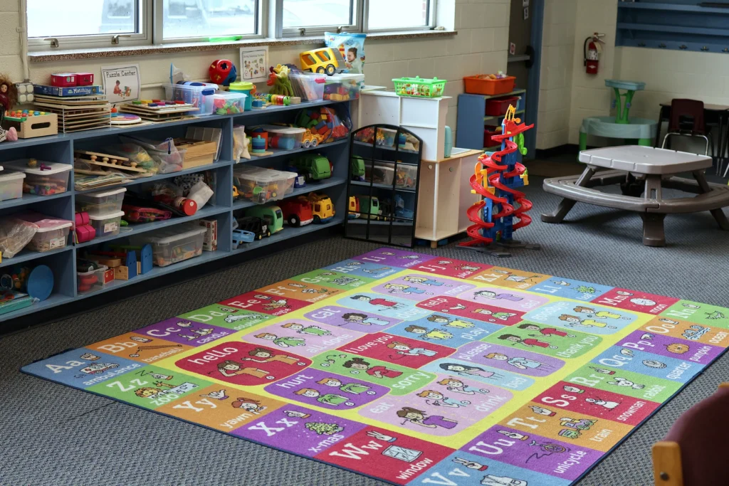 Colorful alphabet rug and organized toy shelves in a Hand in Hand ABA classroom