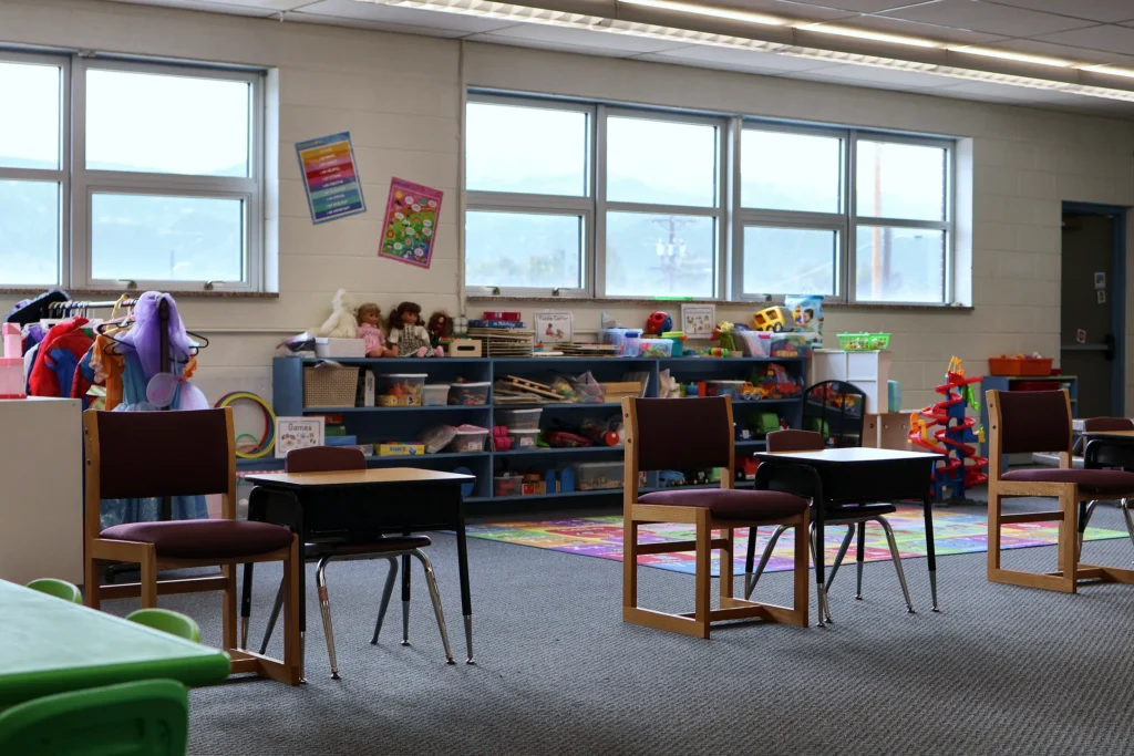 Bright Hand in Hand ABA classroom with desks, large windows and toy shelves