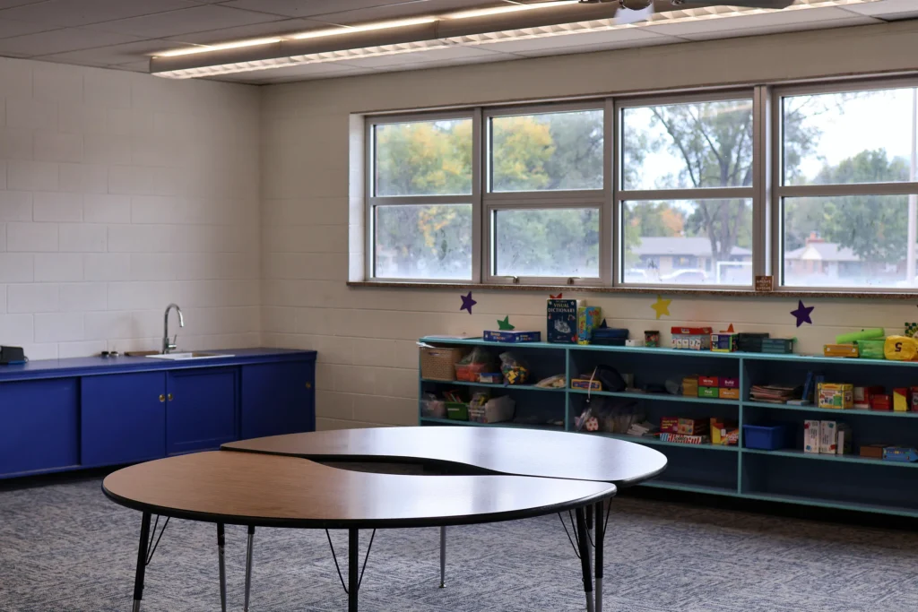 Classroom at Hand in Hand ABA with round group tables and child-size chairs