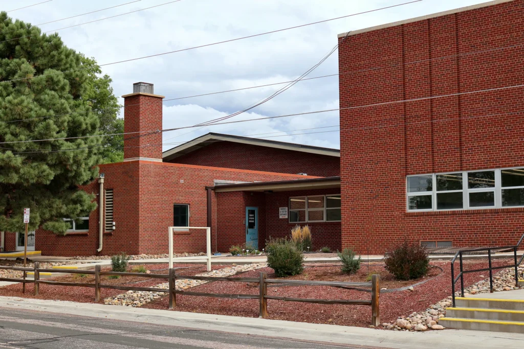 Red brick exterior and landscaped entry of Hand in Hand ABA's clinic and school at 3115 Larkspur Dr, Colorado Springs