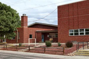 Red brick exterior and landscaped entry of Hand in Hand ABA's clinic and school at 3115 Larkspur Dr, Colorado Springs