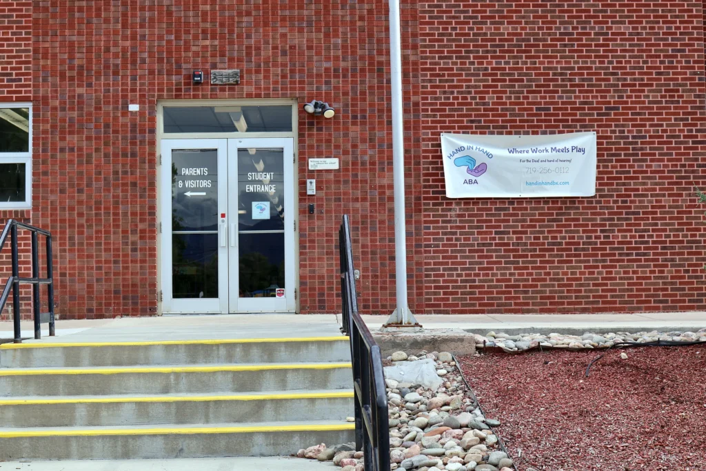 Parents and visitors entrance to Hand in Hand ABA with the clinic's welcome banner, Colorado Springs